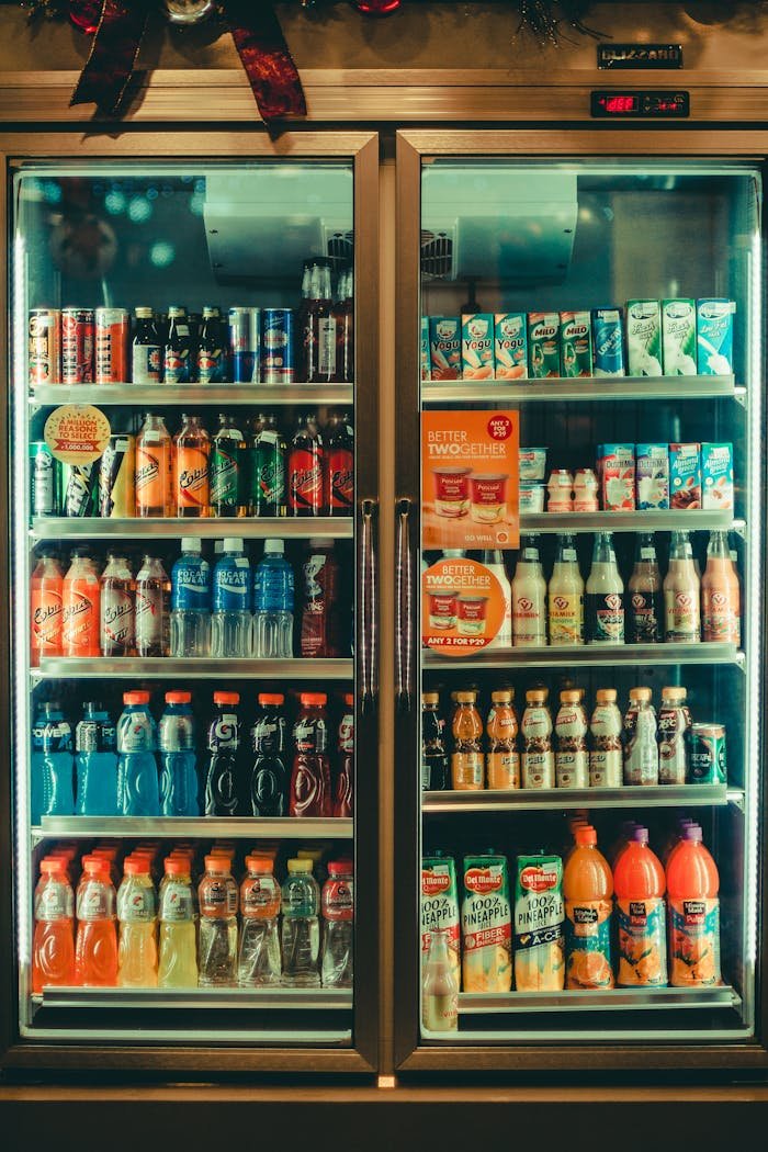 Assorted chilled beverages displayed in a store refrigerator showcasing various drink options for sale.